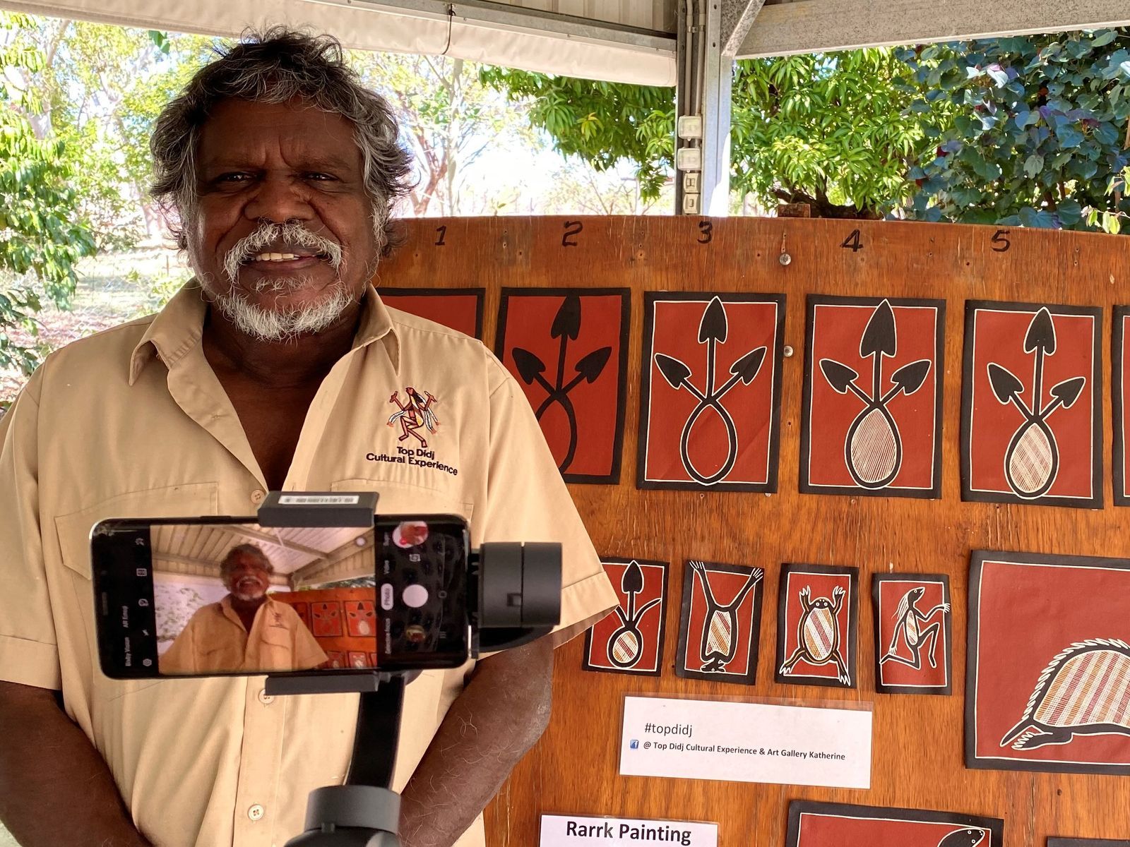 aboriginal guide stands in front of spearheads